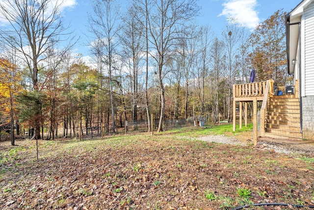 view of yard with fence, stairway, and a wooden deck