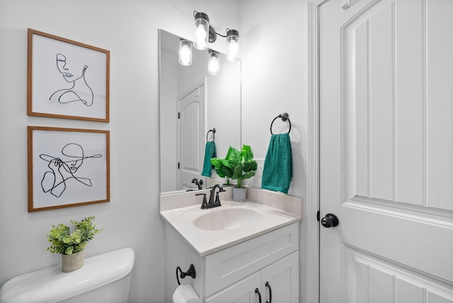 half bathroom featuring vanity and toilet