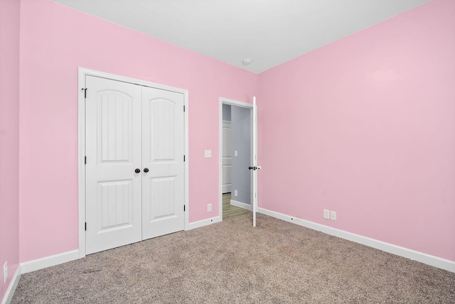 unfurnished bedroom featuring a closet, baseboards, and carpet flooring