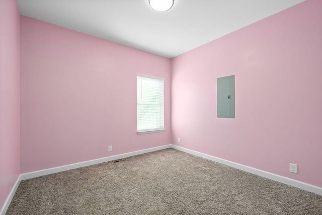 carpeted empty room with electric panel, visible vents, and baseboards