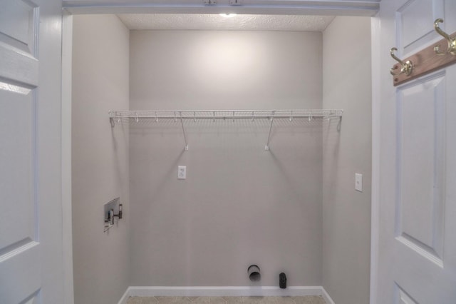 washroom with laundry area, hookup for a washing machine, baseboards, and a textured ceiling