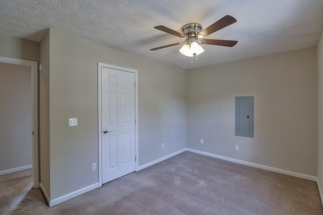 unfurnished bedroom featuring carpet flooring, ceiling fan, a textured ceiling, electric panel, and baseboards