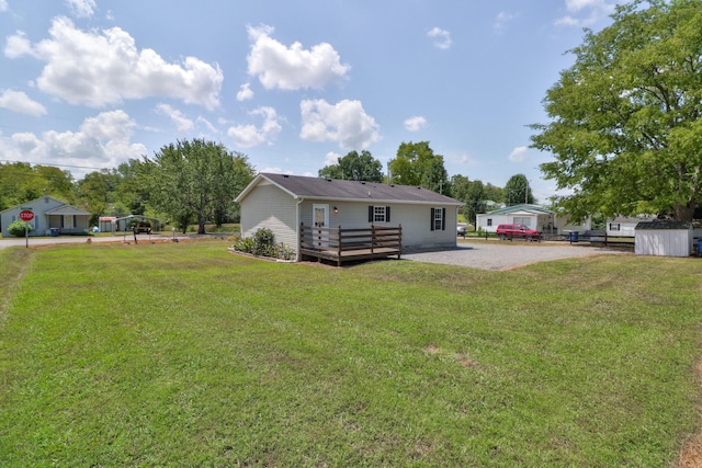 view of yard with driveway and a deck