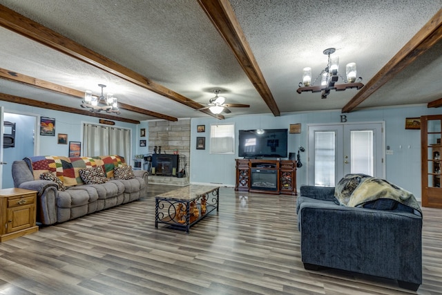 living area featuring french doors, beam ceiling, a textured ceiling, wood finished floors, and ceiling fan with notable chandelier