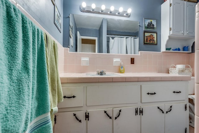 bathroom featuring a shower with curtain, backsplash, and vanity