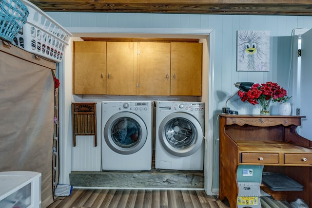 clothes washing area with cabinet space, washing machine and dryer, and wood finished floors