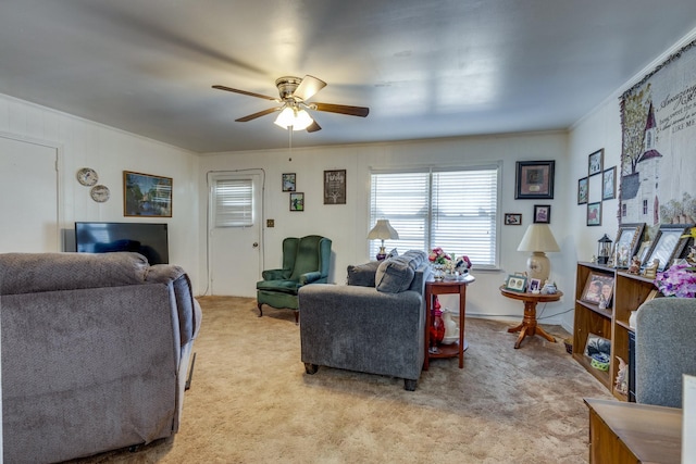 living room featuring light carpet, a ceiling fan, and crown molding