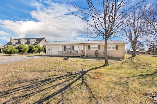 ranch-style home with a garage, driveway, brick siding, and a front lawn