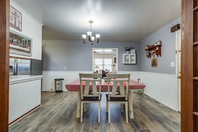 dining room featuring a chandelier, wainscoting, and wood finished floors