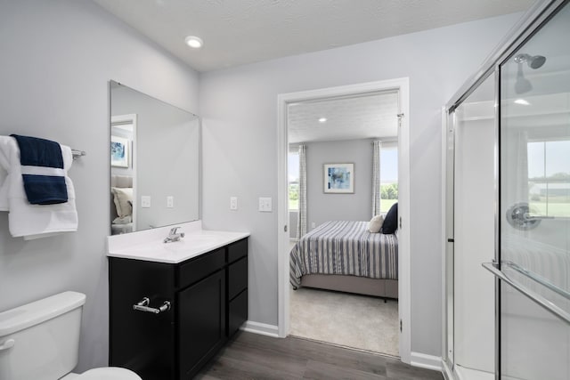 full bath with a stall shower, ensuite bath, wood finished floors, and vanity