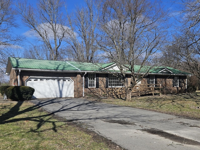 view of front of property with aphalt driveway, an attached garage, and brick siding