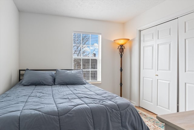 bedroom featuring a closet, a textured ceiling, and wood finished floors