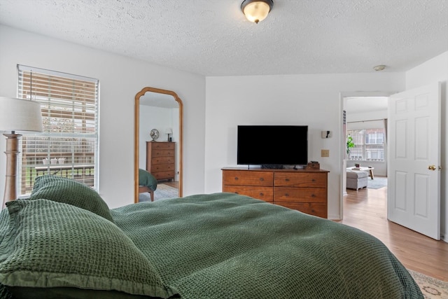 bedroom featuring a textured ceiling and wood finished floors