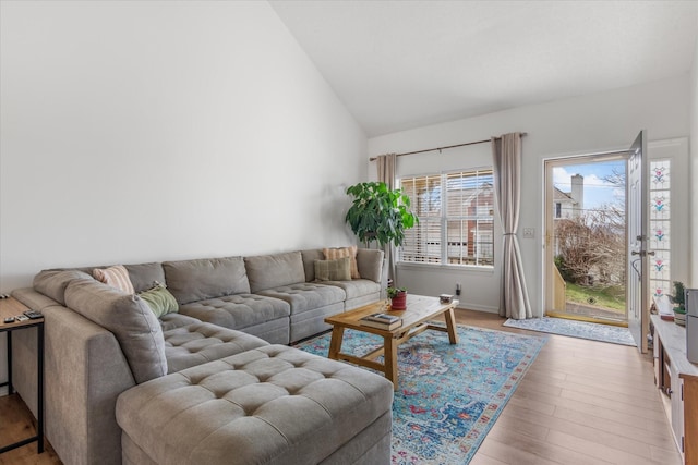 living room featuring lofted ceiling and light wood-style floors