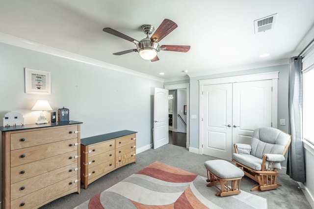 bedroom featuring crown molding, a closet, baseboards, visible vents, and carpet