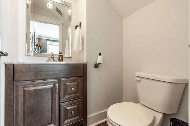 bathroom featuring vaulted ceiling, toilet, vanity, baseboards, and visible vents