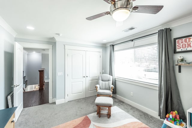 living area featuring baseboards, visible vents, ceiling fan, and carpet flooring