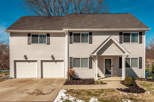 view of front of property with a garage, roof with shingles, and driveway