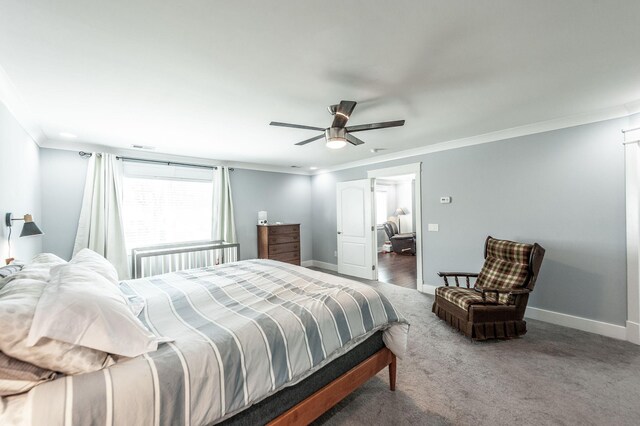 carpeted bedroom featuring baseboards, crown molding, and a ceiling fan
