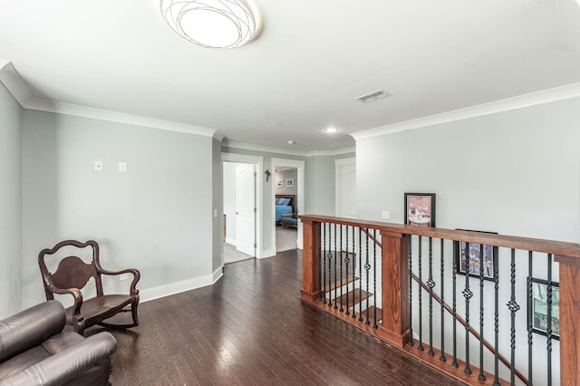 sitting room with crown molding, an upstairs landing, wood finished floors, baseboards, and visible vents