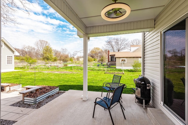view of patio with fence and a grill