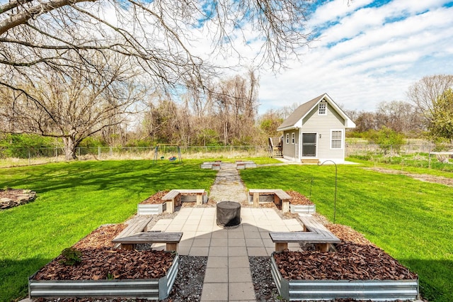 view of yard with a fenced backyard, an outdoor structure, a vegetable garden, and a patio area