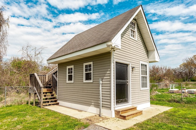 view of outdoor structure featuring an outbuilding, fence, and stairway