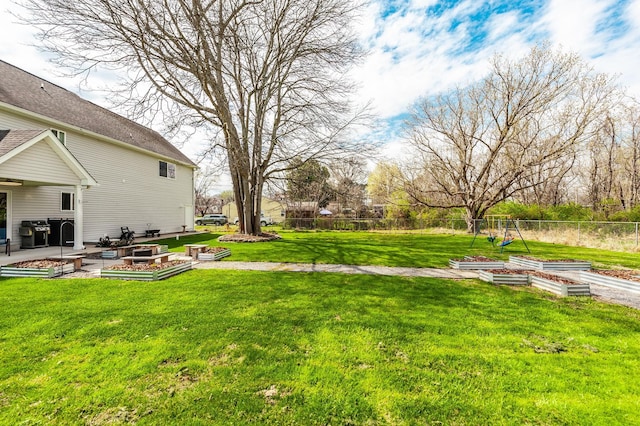view of yard with a vegetable garden, fence, and a patio