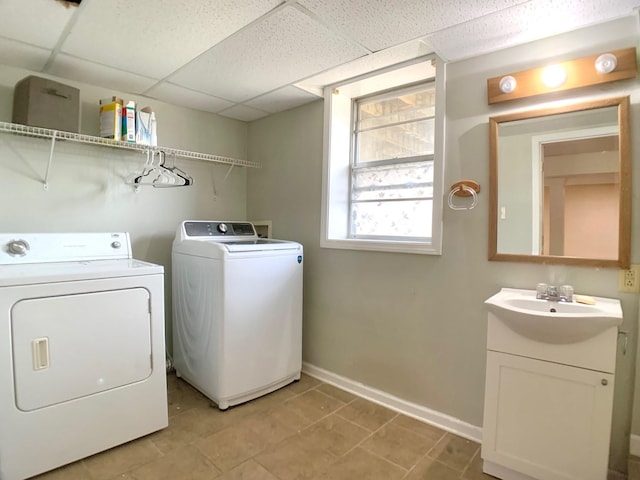 laundry room featuring laundry area, baseboards, washer and clothes dryer, and a sink