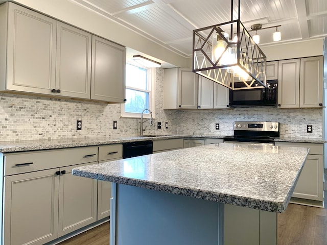 kitchen featuring light stone counters, gray cabinets, a sink, a kitchen island, and black appliances