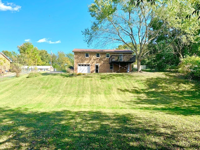 back of house with a garage, a yard, and a wooden deck