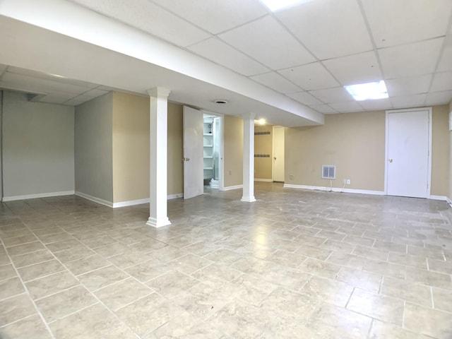 finished basement featuring a paneled ceiling, baseboards, and visible vents