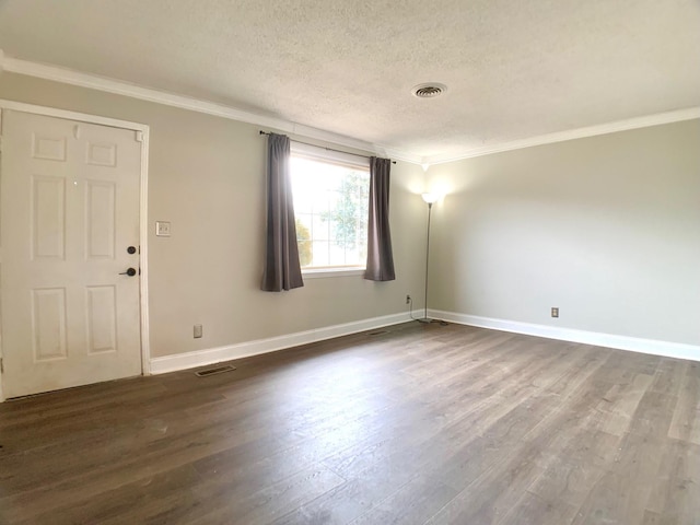 spare room featuring visible vents, dark wood finished floors, and ornamental molding