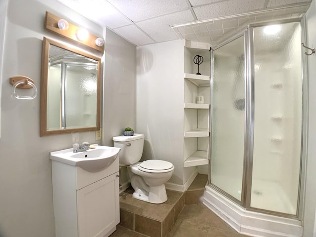 full bath featuring toilet, tile patterned flooring, vanity, a paneled ceiling, and a shower stall