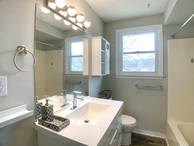 bathroom featuring a textured ceiling, toilet, vanity, visible vents, and baseboards