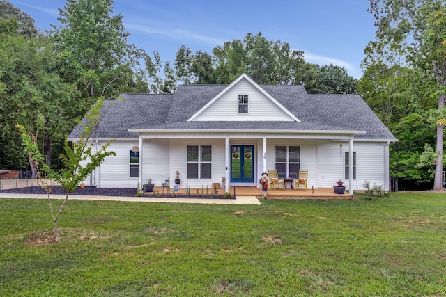 view of front of house featuring covered porch, a shingled roof, and a front lawn