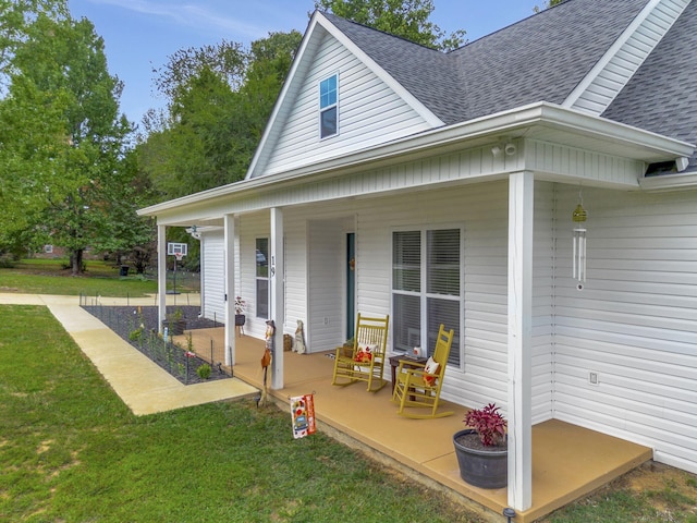 exterior space with a shingled roof, a porch, and a yard