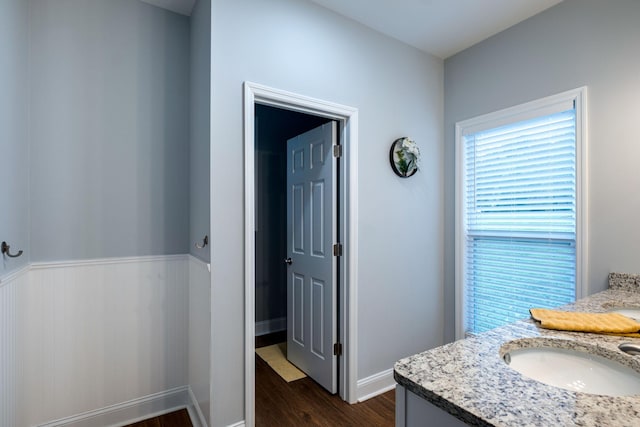 bathroom featuring baseboards, wood finished floors, and vanity