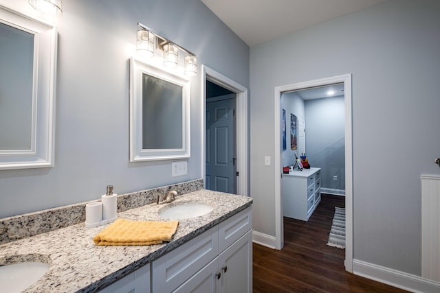 full bath with wood finished floors, vanity, and baseboards