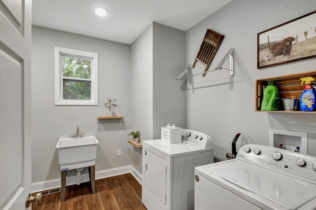 clothes washing area featuring washer and dryer, laundry area, baseboards, and dark wood-style flooring