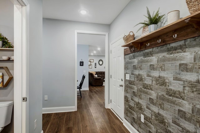 hallway with dark wood-style flooring and baseboards