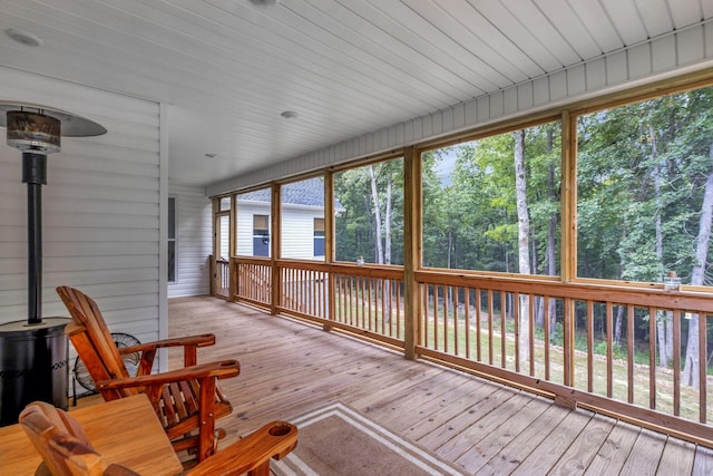 unfurnished sunroom with a wood stove