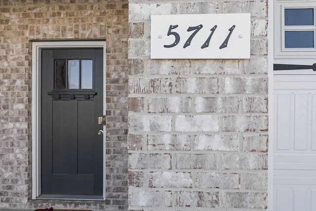 view of exterior entry with brick siding