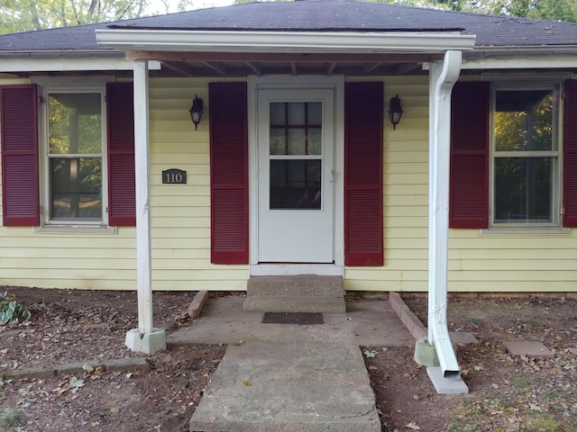 property entrance featuring roof with shingles