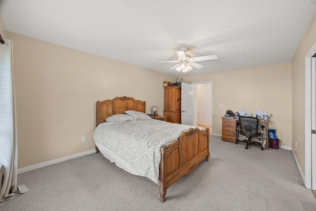 bedroom with light carpet, a textured ceiling, a ceiling fan, and baseboards