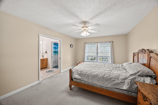 bedroom with light carpet, a textured ceiling, a ceiling fan, and baseboards