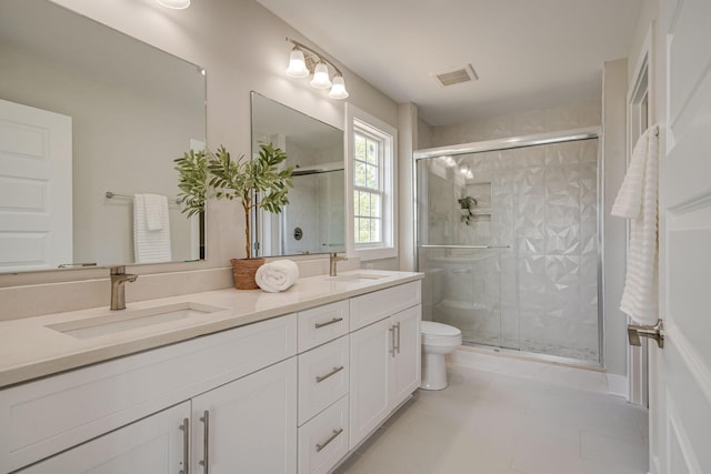 full bath featuring visible vents, a sink, a shower stall, and double vanity