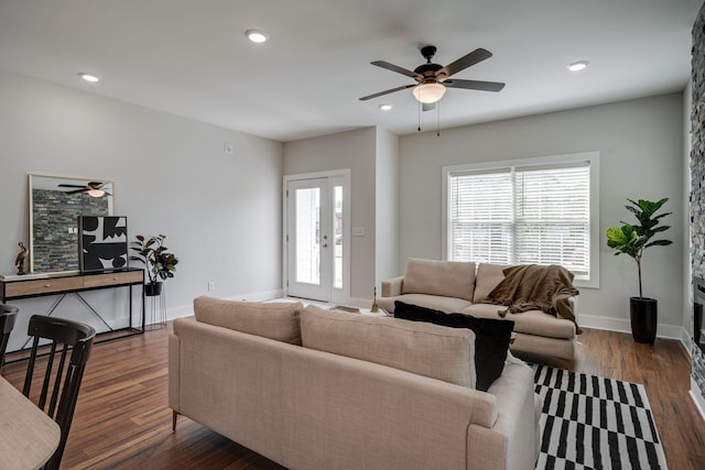 living area featuring a healthy amount of sunlight, baseboards, dark wood finished floors, and recessed lighting