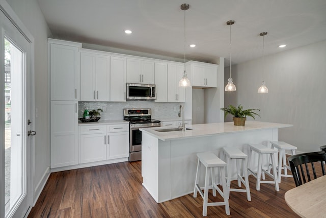 kitchen with appliances with stainless steel finishes, white cabinets, light countertops, and a sink