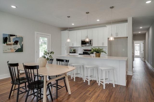 dining space featuring dark wood-type flooring, recessed lighting, and baseboards